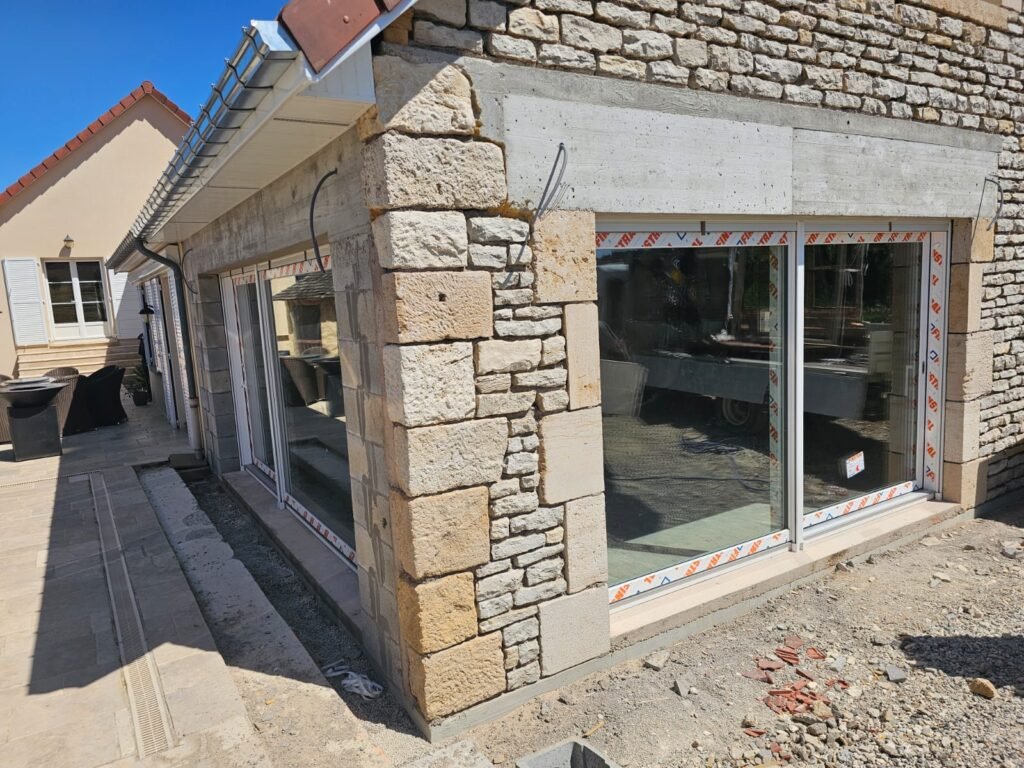 Façade en pierre de taille avec baies levant-coulissant Finstral posées sur construction neuve à Balesmes-sur-Marne Menuiserie Foultot