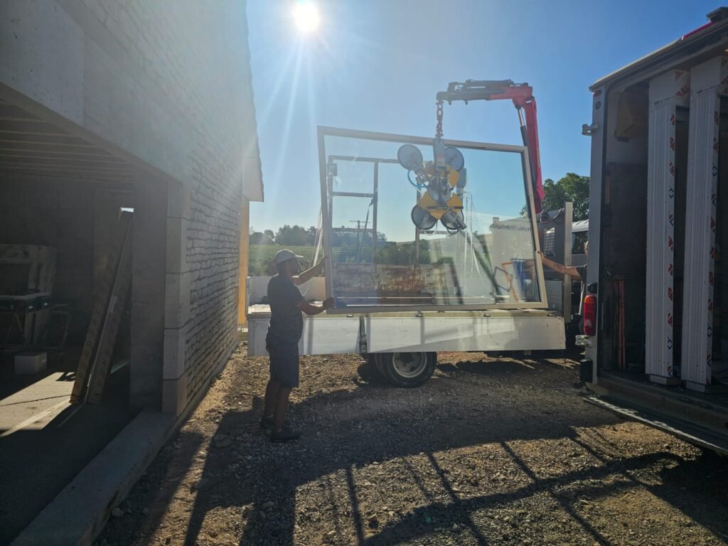 Levage à la grue d'une baie levant-coulissant Finstral de 500 kg par l'équipe Menuiserie Foultot à Balesmes-sur-Marne Haute-Marne