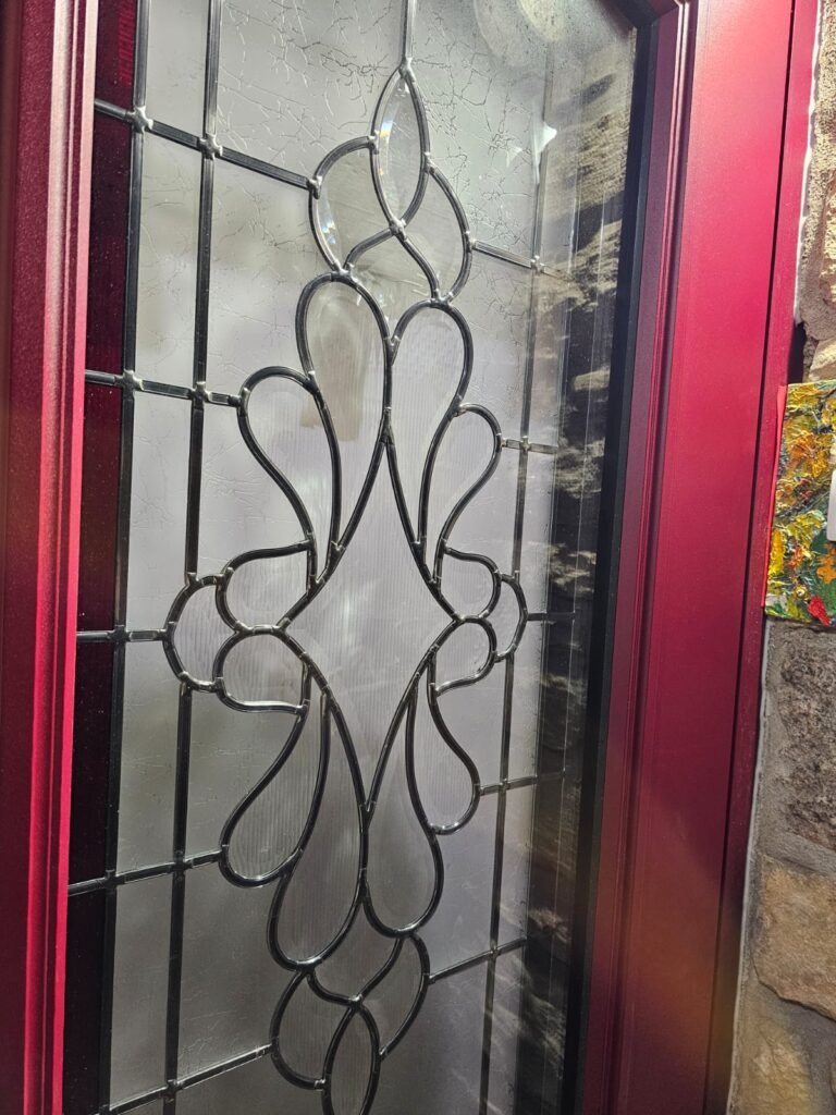 Détail du vitrage décoratif au plomb fait main d'une porte d'entrée Inotherm rouge