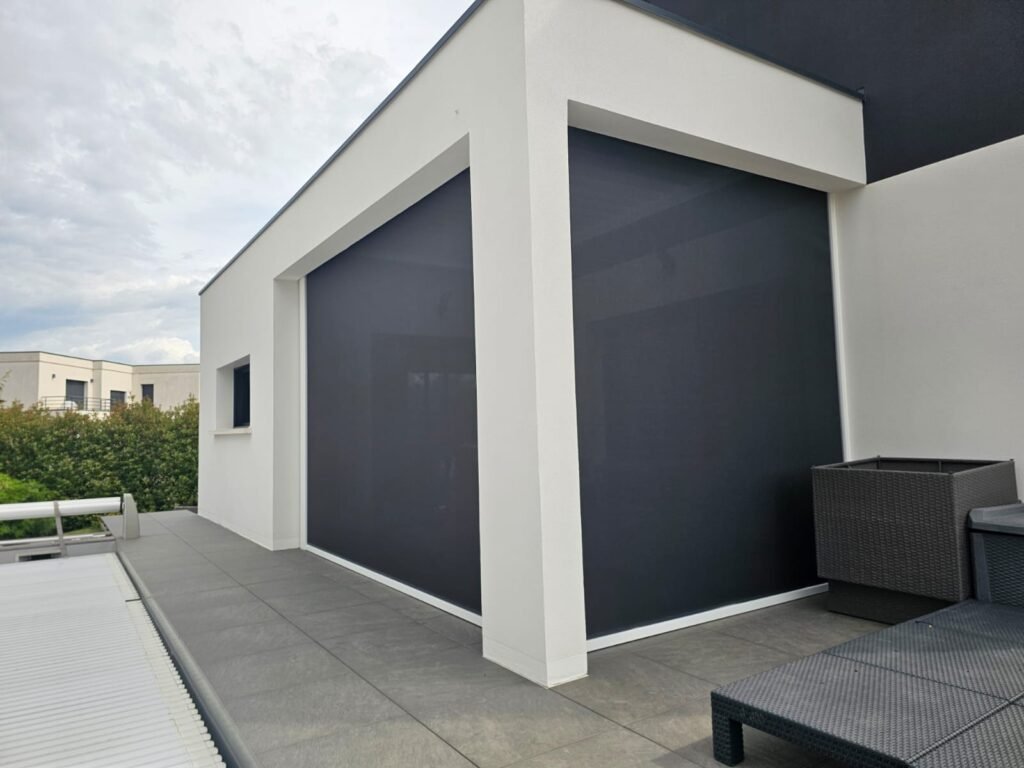 Angle de façade avec pergola intégrée dans l'ossature béton et screens fermés