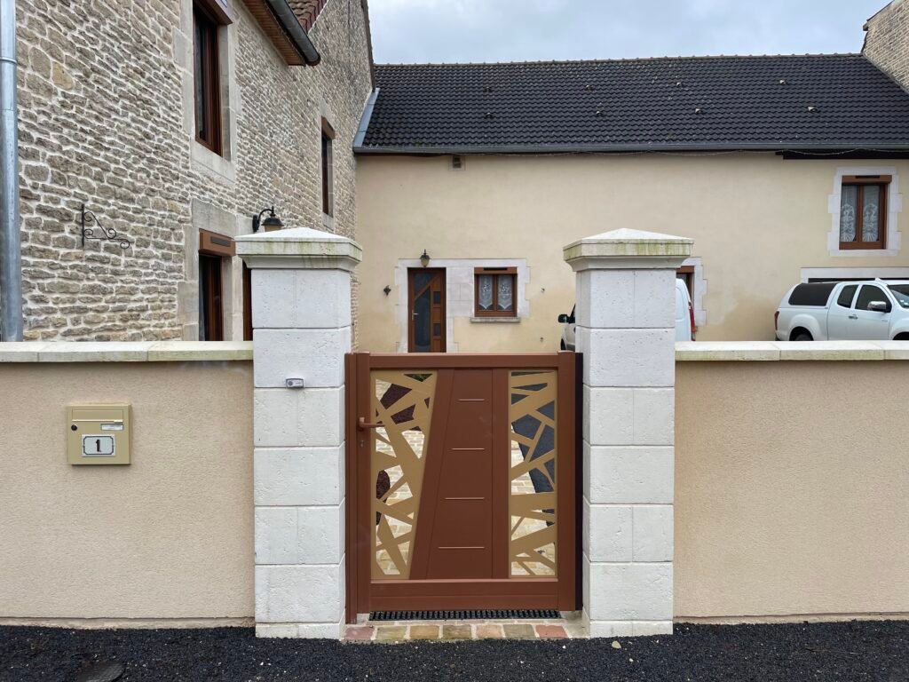 Portillon en aluminium CETAL installé entre des piliers en pierre par Menuiserie Foultot