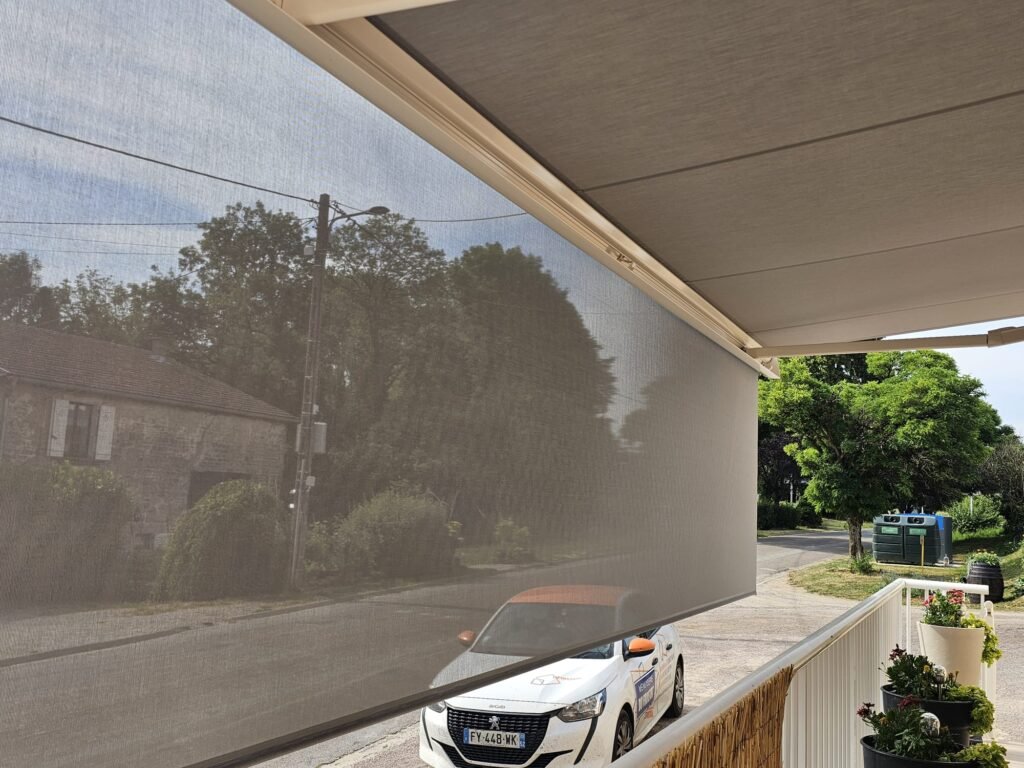 Vue sous le store banne Brustor déployé avec lambrequin face à la rue