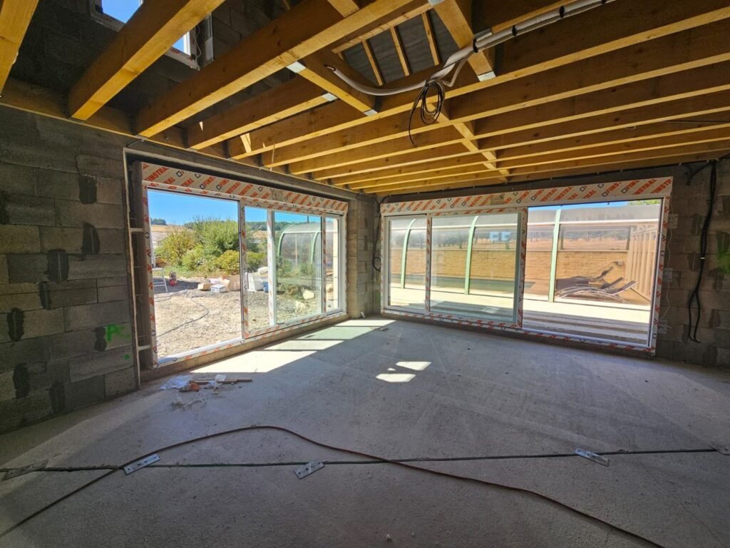 Vue intérieure pendant pose des deux baies levant-coulissant Finstral dans construction neuve à Balesmes-sur-Marne Menuiserie Foultot