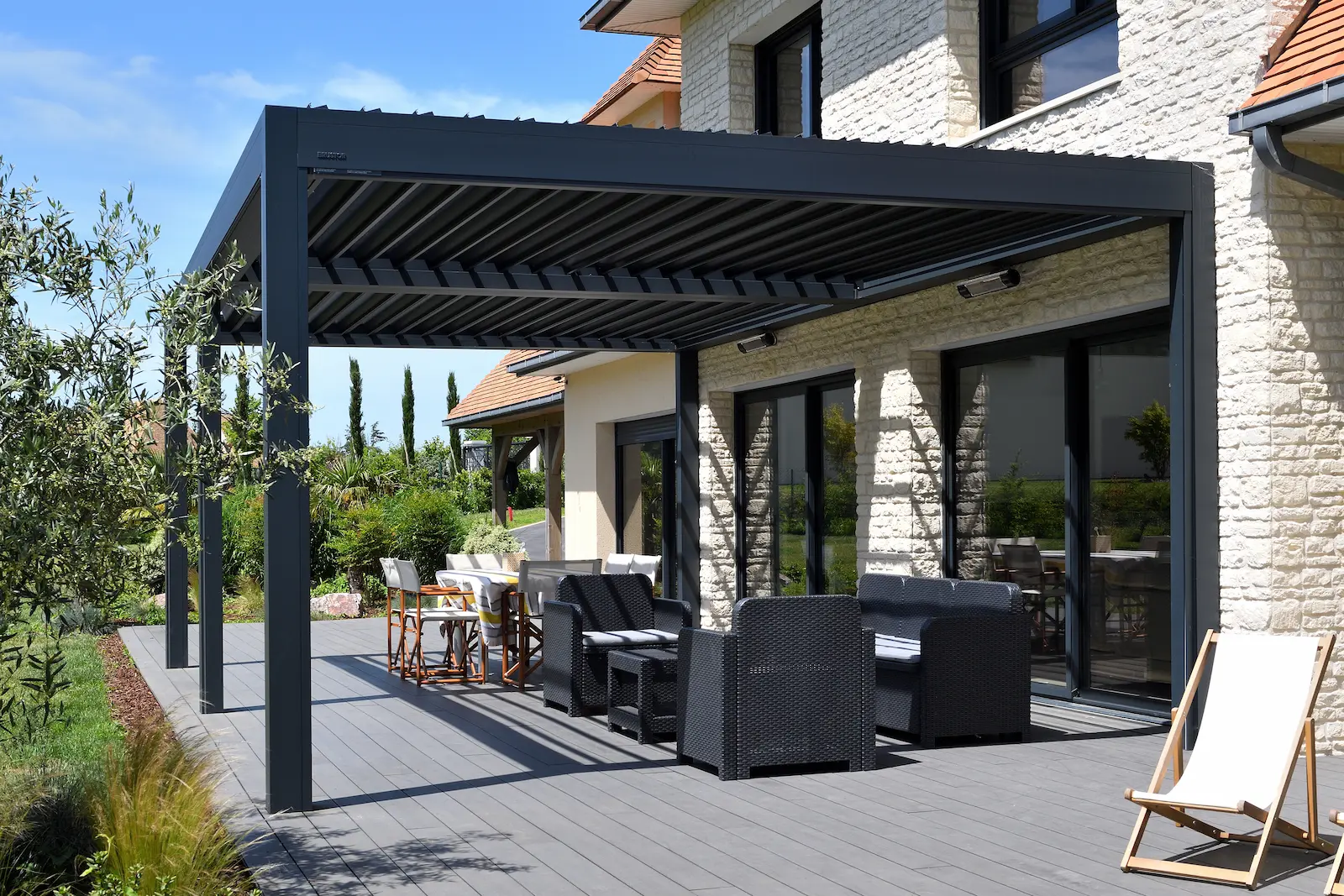 Pergola bioclimatique anthracite intégrée sur maison ancienne en pierre bourguignonne, contraste contemporain