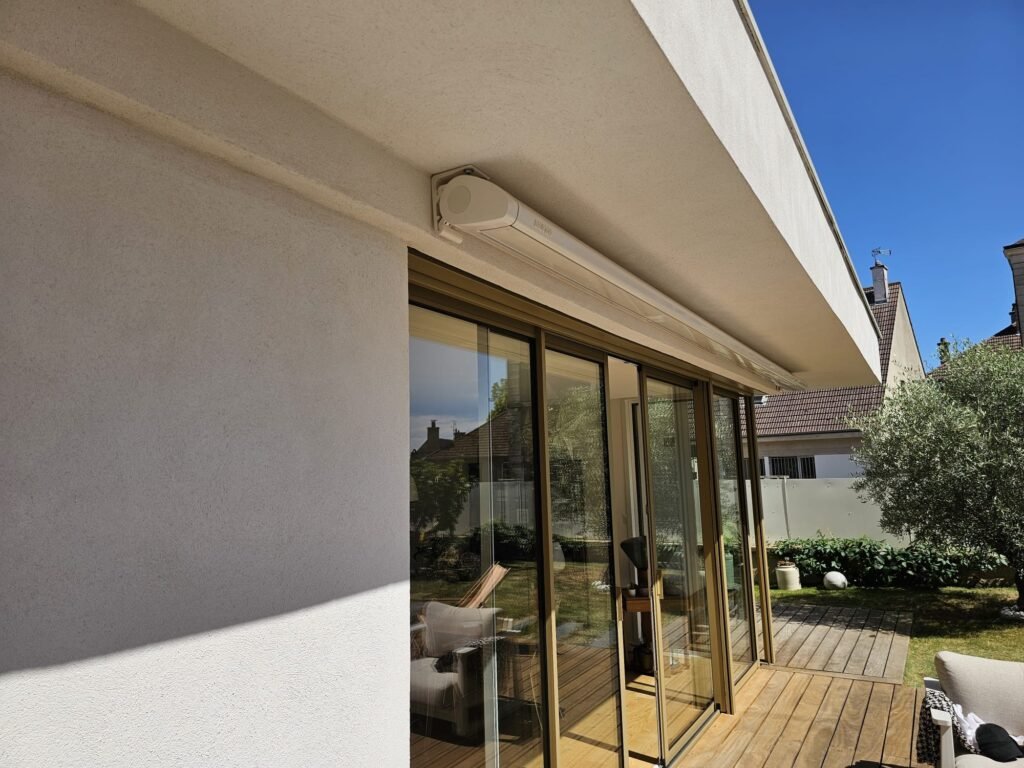 Coffre blanc du store banne Brustor B50S fixé sous l'avancée de toit d'une maison contemporaine à Messigny-et-Vantoux (21), Menuiserie Foultot