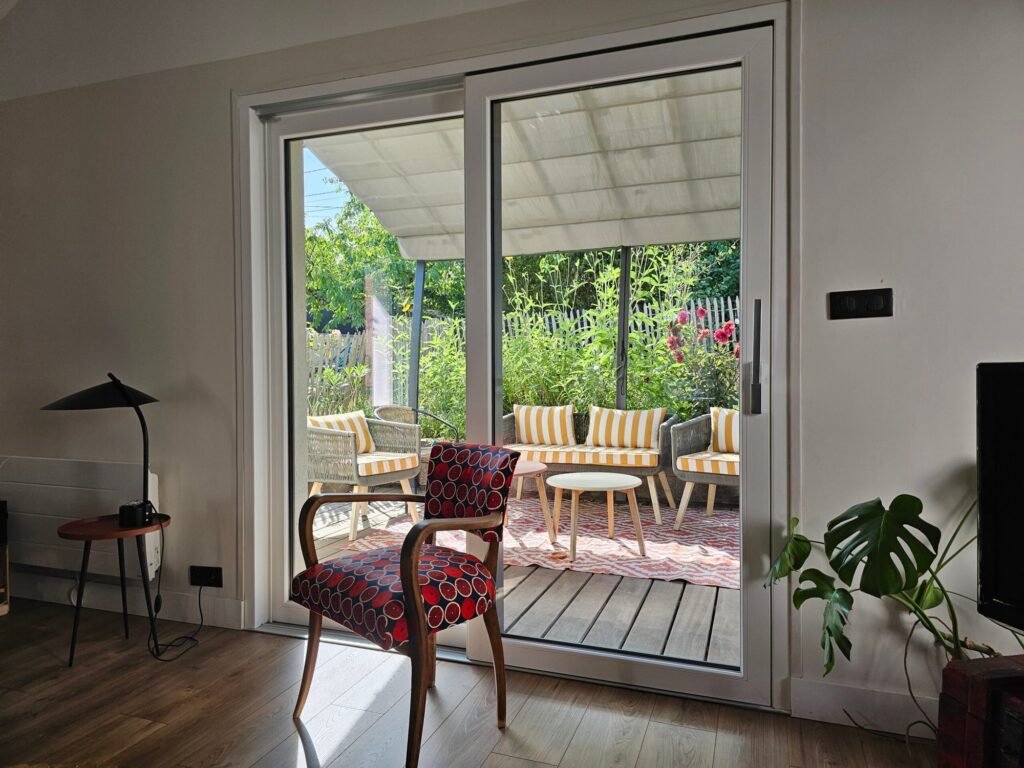 Vue intérieure de la baie levant-coulissant Finstral PVC blanc depuis le séjour avec vue sur terrasse et jardin Dijon Côte-d'Or, Menuiserie Foultot