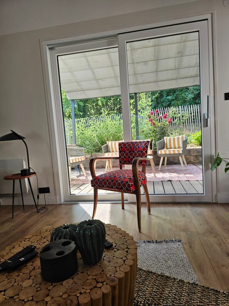 Baie levant-coulissant Finstral PVC blanc, entrouverte sur la terrasse avec son seuil bas affleurant et poignée anthracite - Dijon, Menuiserie Foultot