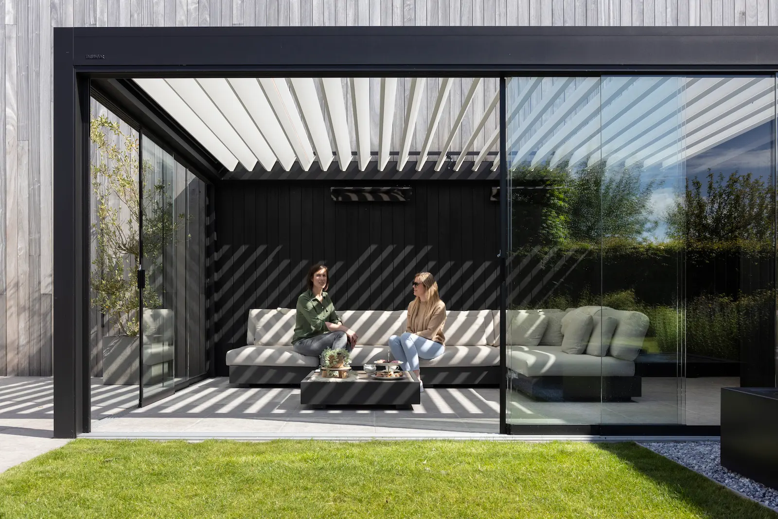 Damier d'ombres projeté au sol par les lames orientables d'une pergola bioclimatique aluminium
