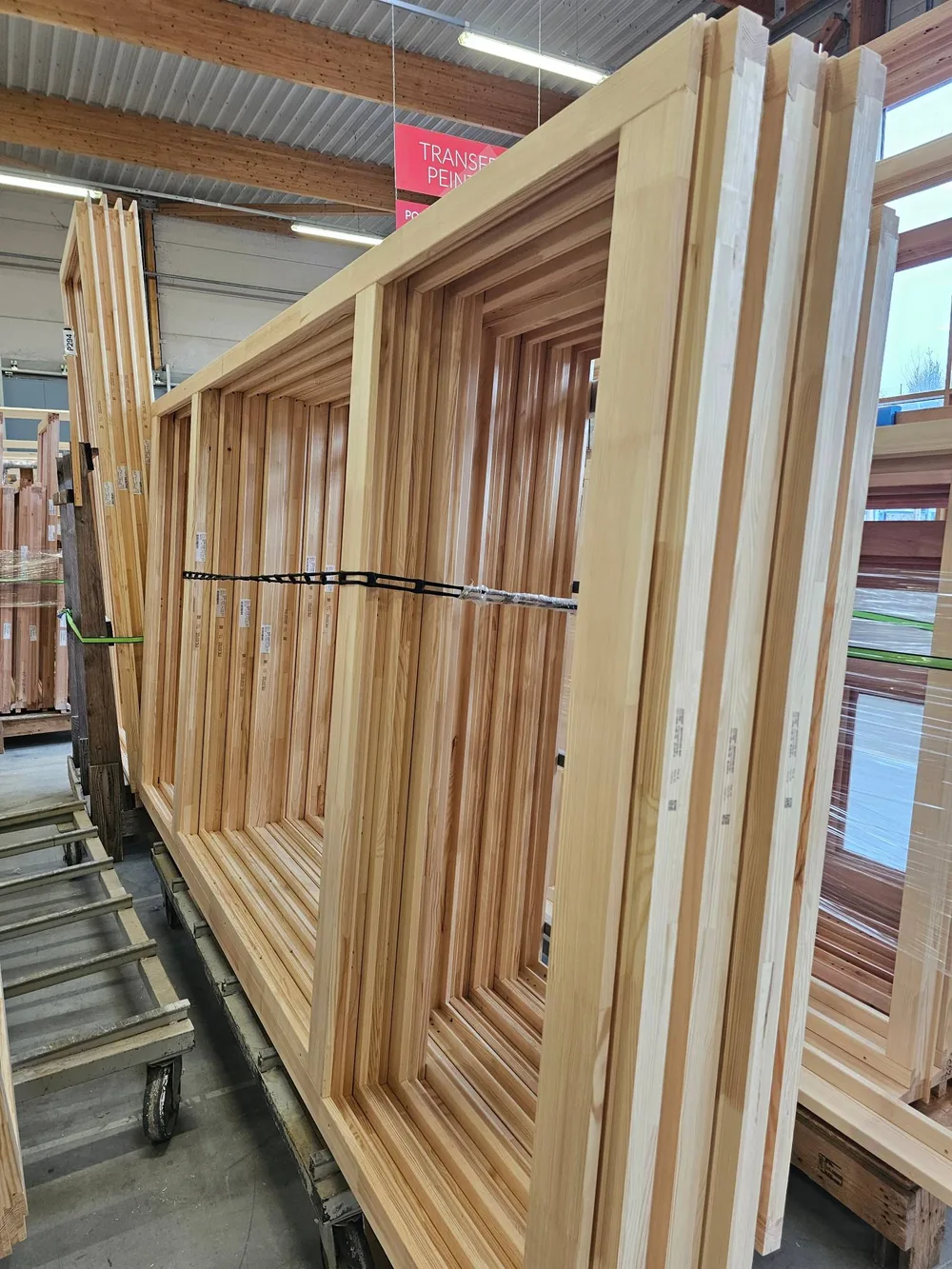 Châssis de fenêtres bois Bieber à l'état brut, sanglés sur chariot en attente de peinture, dans l'atelier de Waldhambach en Alsace