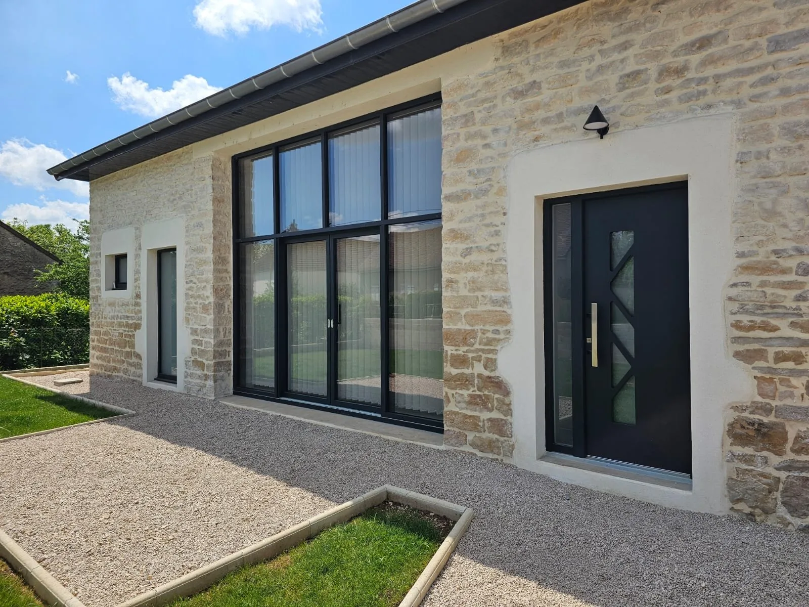 Fenêtres et baie vitrée Finstral posées sur une maison en pierre à Échenon