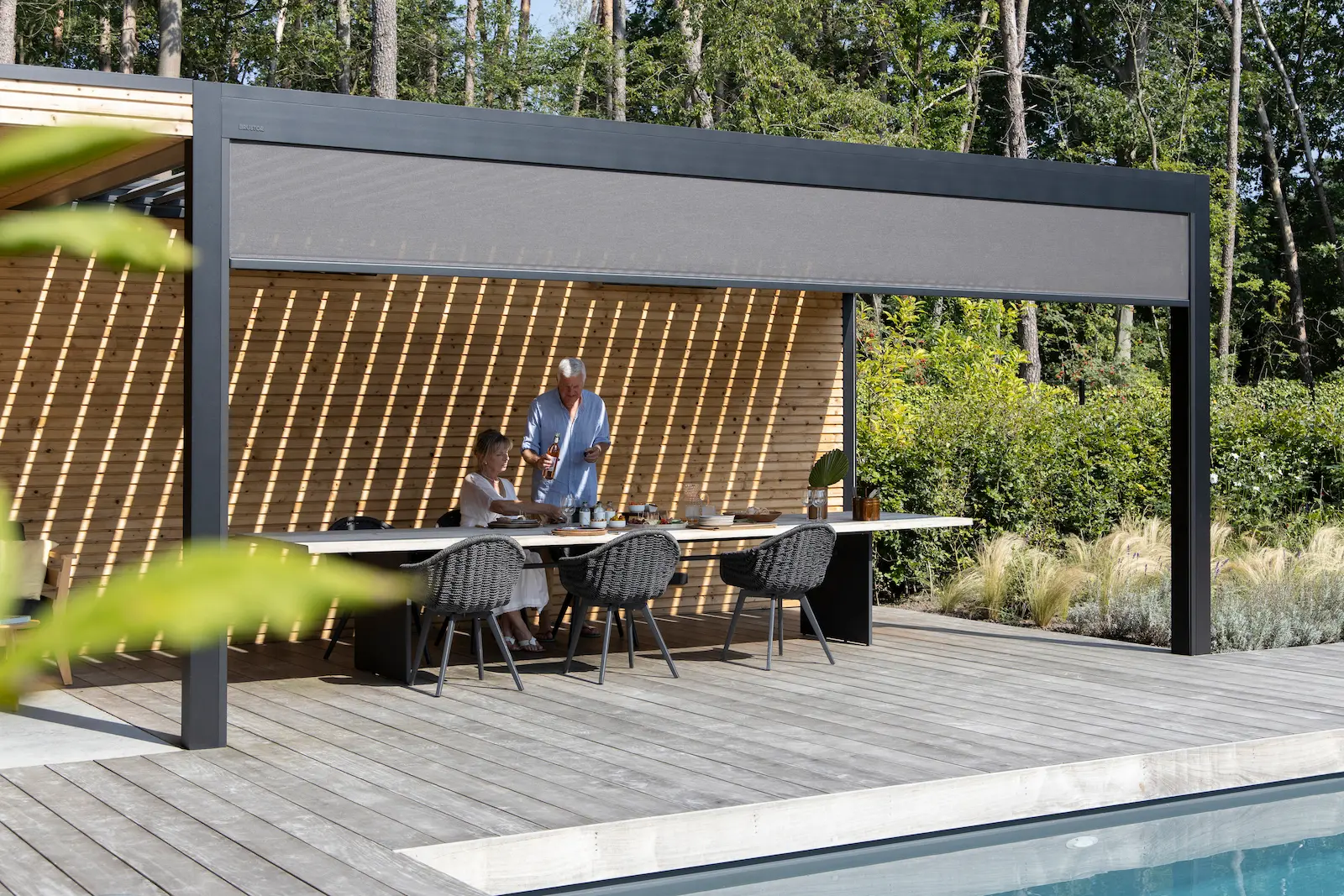 Pergola bioclimatique aluminium gris anthracite Brustor sur terrasse contemporaine en Côte-d'Or, lames orientables motorisées
