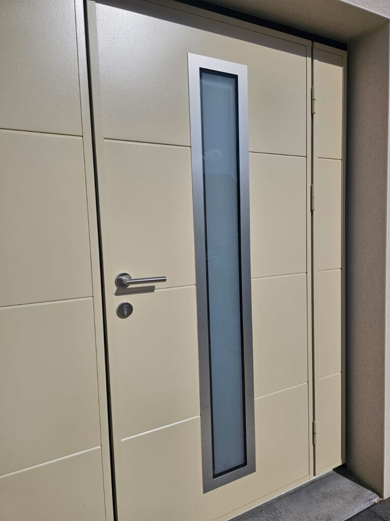 Gros plan portillon intégré avec poignée inox et insert vitré pleine hauteur sur porte basculante Moos - Varois-et-Chaignot, Menuiserie Foultot