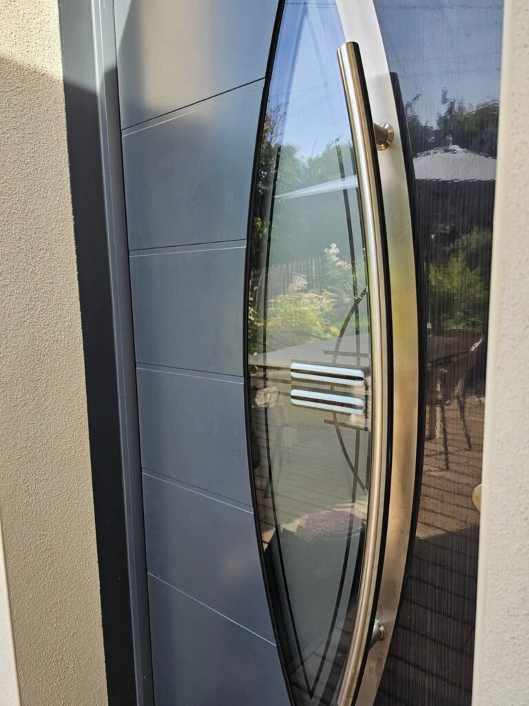 Vue extérieure de l'insert ovale inox et barre de tirage de la porte Inotherm aluminium gris anthracite - Dijon, Menuiserie Foultot