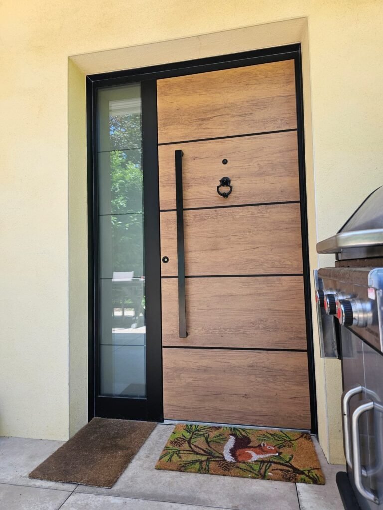Porte d'entrée aluminium Inotherm chêne vieilli avec fixe latéral vitré et encadrement noir, posée à Langres par Menuiserie Foultot