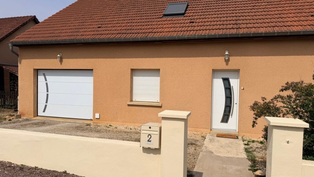 Ensemble coordonné porte d'entrée Inotherm et porte de garage sectionnelle Gypass blanches à Jonchery (52).