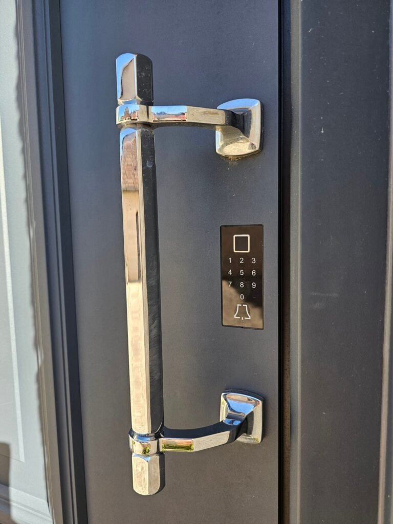 Gros plan barre de tirage chromée et digicode Ino Smart avec lecteur d'empreinte digitale sur porte Inotherm gris ardoise - Langres, Menuiserie Foultot
