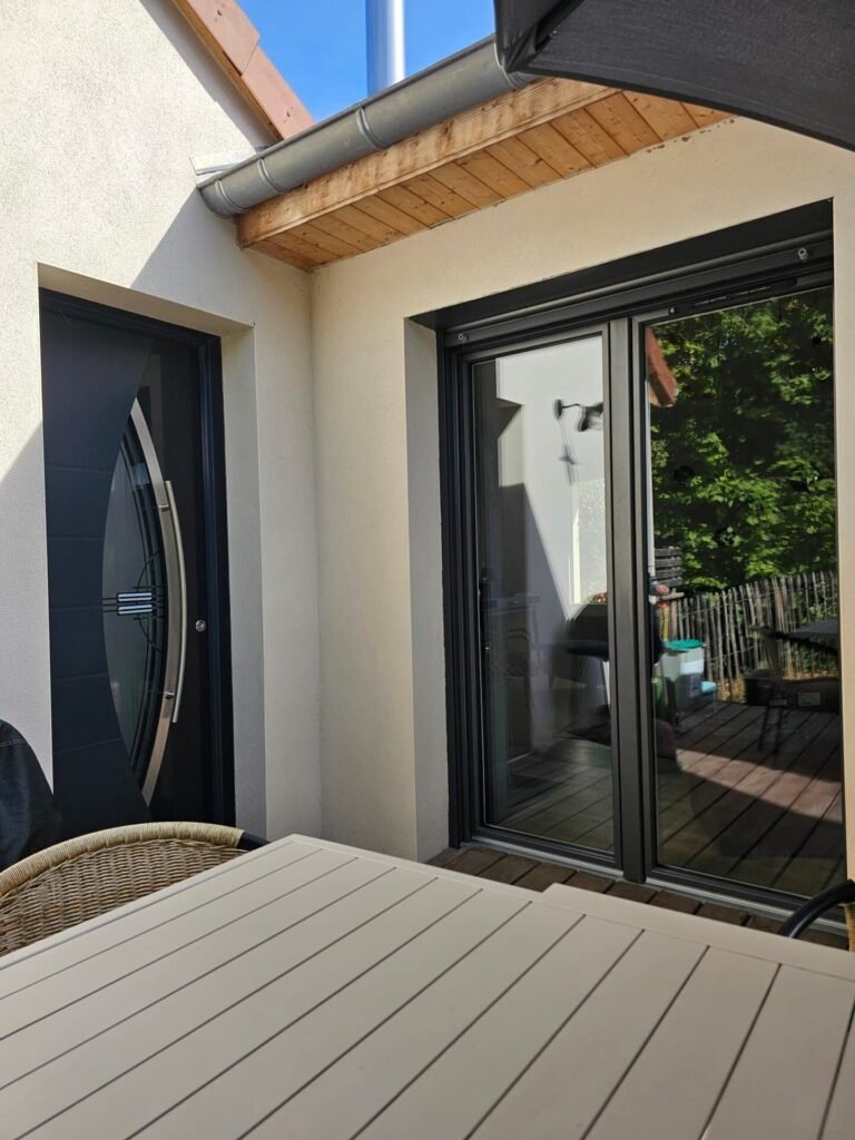Ensemble porte d'entrée Inotherm et porte-fenêtre Finstral aluminium gris anthracite sur terrasse bois à Dijon