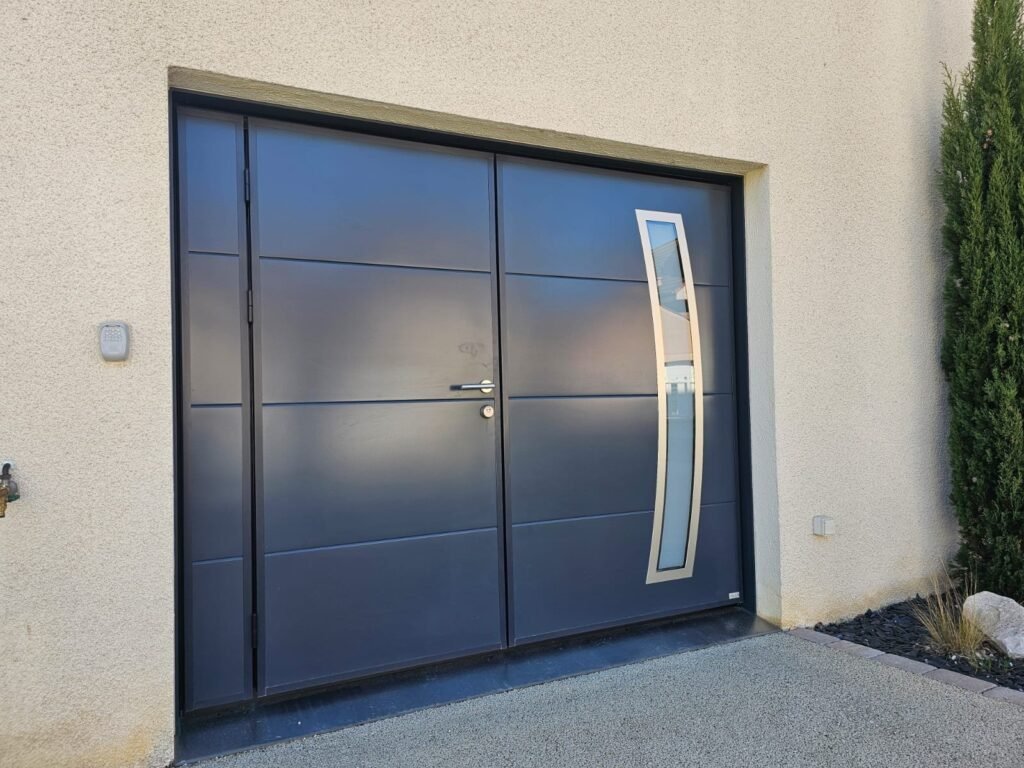 Porte de garage basculante Moos RAL 7016 à portillon intégré et hublots inox en arc, vue de face, Quetigny