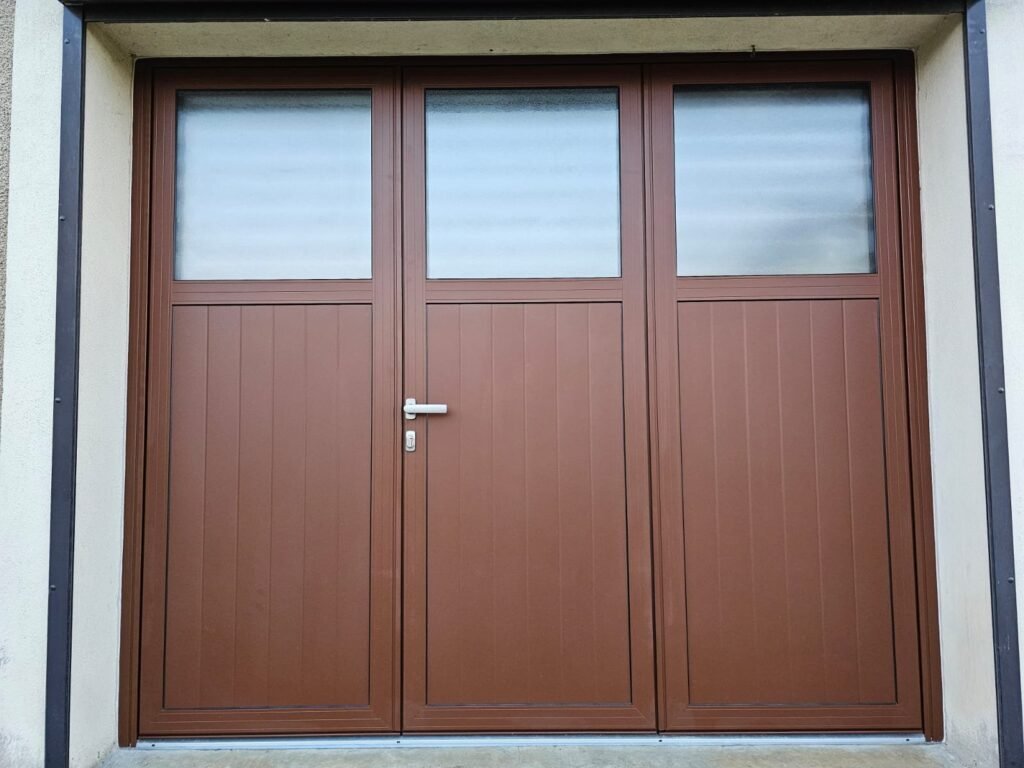 Porte de garage battante aluminium Gypass trois vantaux RAL 8014 avec vitrage satiné, posée à Maulain par Menuiserie Foultot