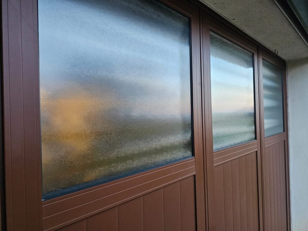 Détail du vitrage satiné de la porte de garage battante aluminium Gypass, Maulain