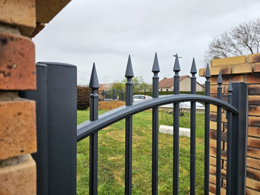 Pointes de flèche en aluminium sur la traverse cintrée du portail Cetal Pléiade, Dommarien