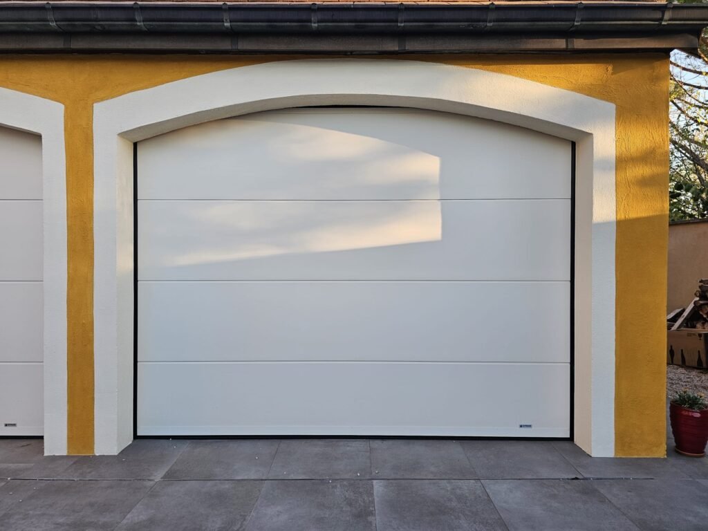 Seconde porte de garage sectionnelle Gypass sous arc cintré, vue de face, Rouvres-en-Plaine