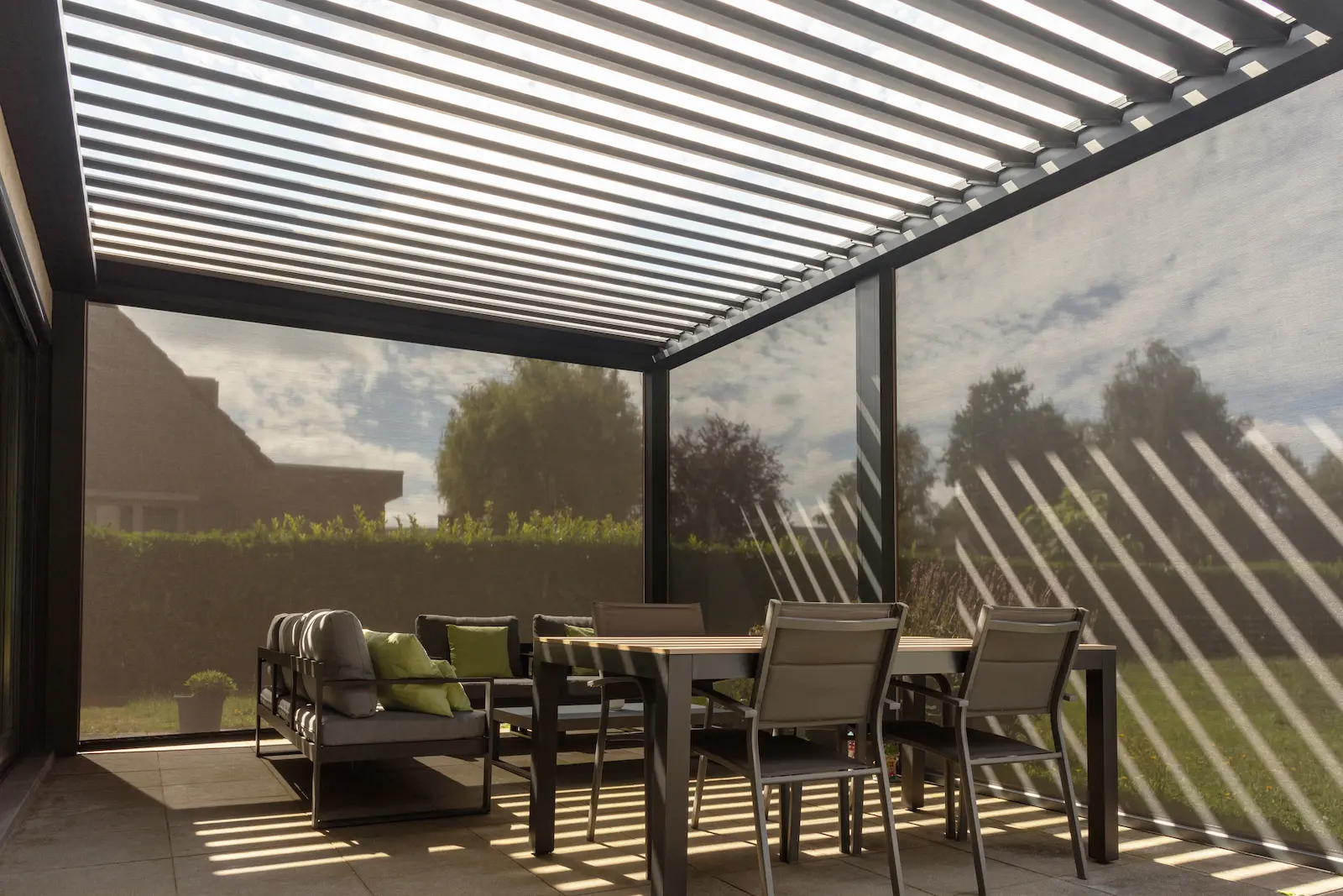 Store latéral ZIP microperforé descendu sur une pergola bioclimatique, filtration solaire
