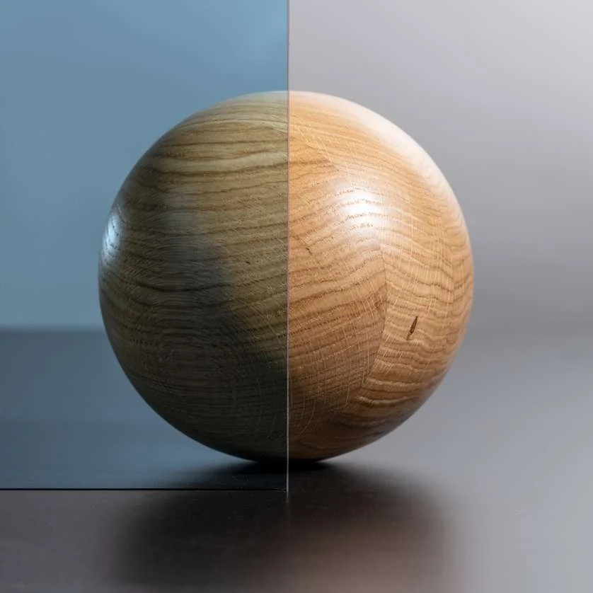 Sphère en bois vue à travers un verre à contrôle solaire à gauche et un verre clair à droite : la teinte assombrit nettement l'image (photo Finstral)