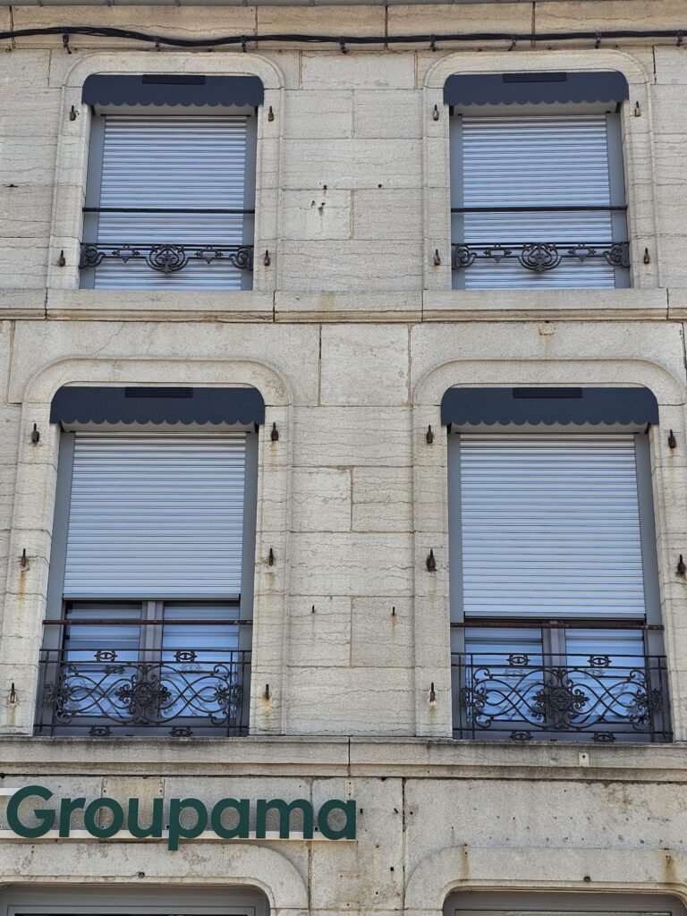 Zoom sur les volets roulants solaires avec lambrequins posés sur une façade en pierre à Fayl-Billot (52).