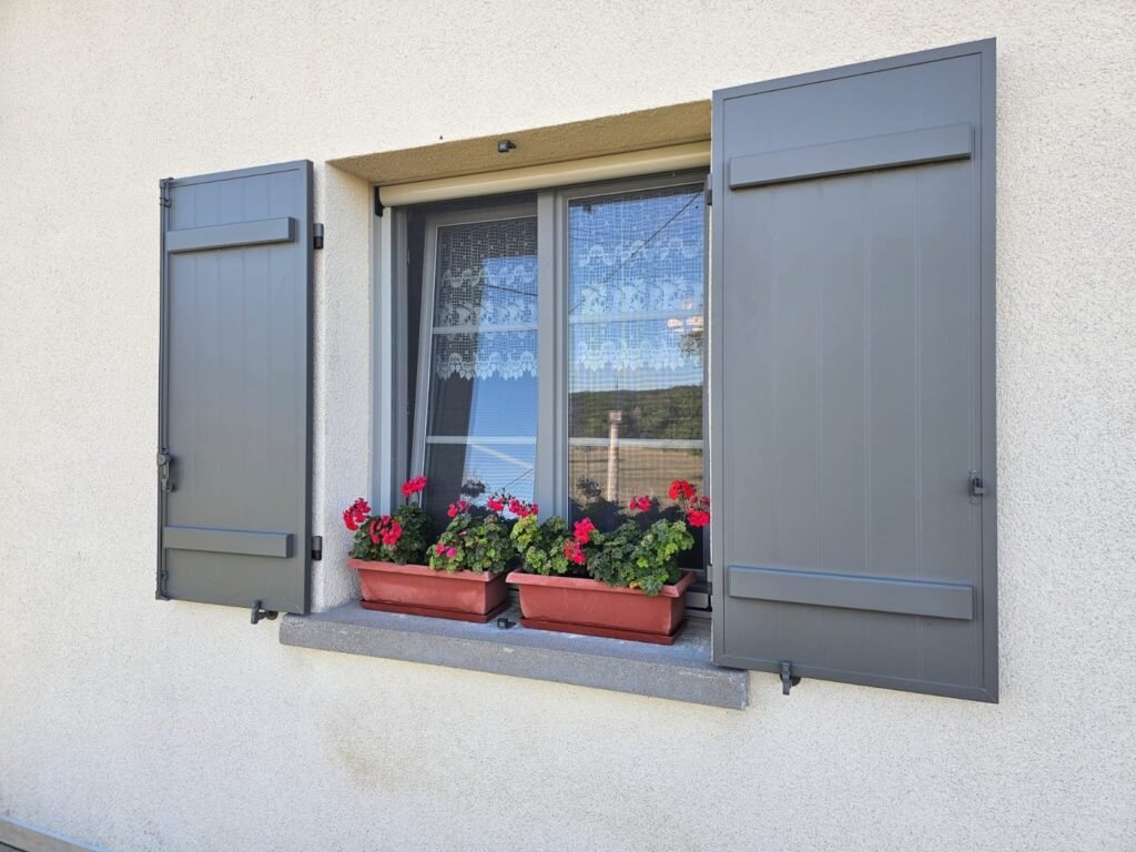 Fenêtre PVC Finstral gris 46 à petits bois intégrés, volets battants Ehret ouverts, vue de côté, Champigneulles-en-Bassigny