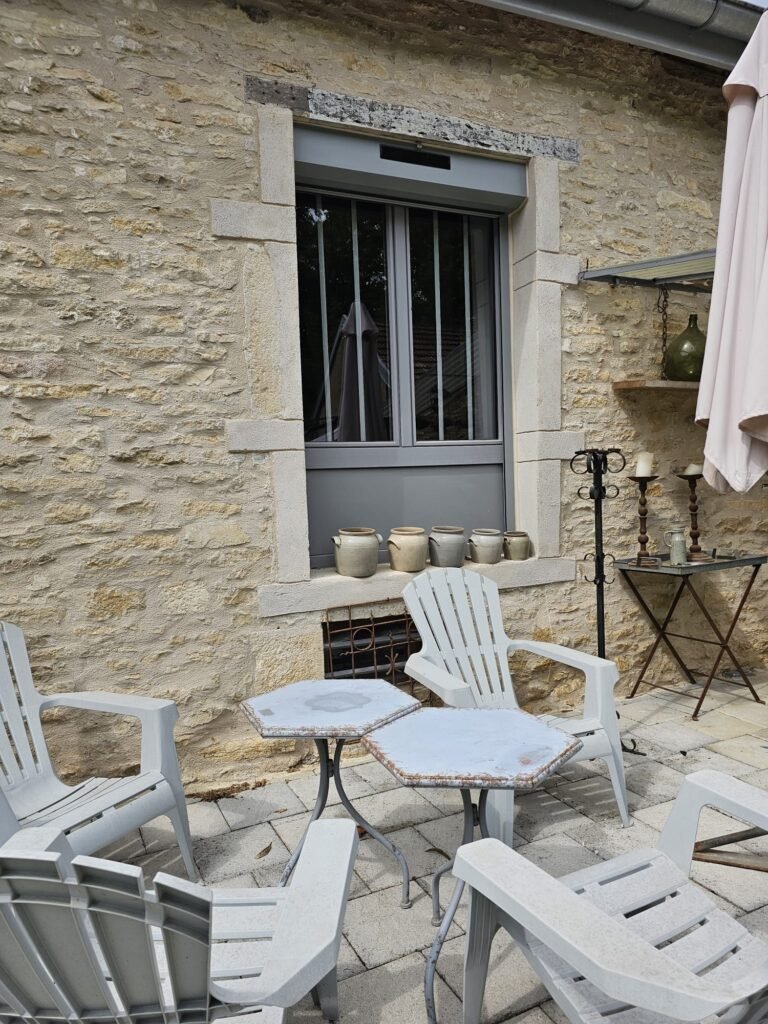 Fenêtre PVC gris Finstral avec petits bois verticaux et panneau plein côté terrasse à Fontaine-Française
