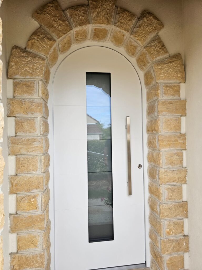 Porte d'entrée blanche cintrée Inotherm avec insert vitré dépoli et barre de tirage inox, Orgeux