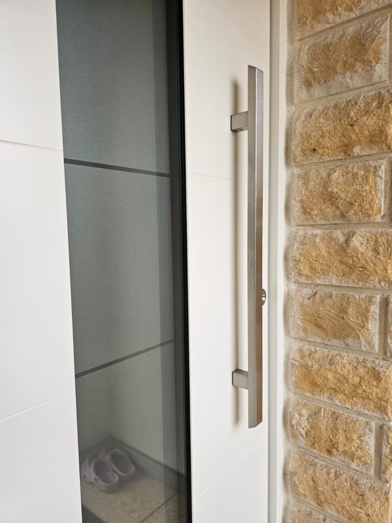 Barre de tirage inox et rosace de sécurité sur la porte d'entrée Inotherm d'Orgeux