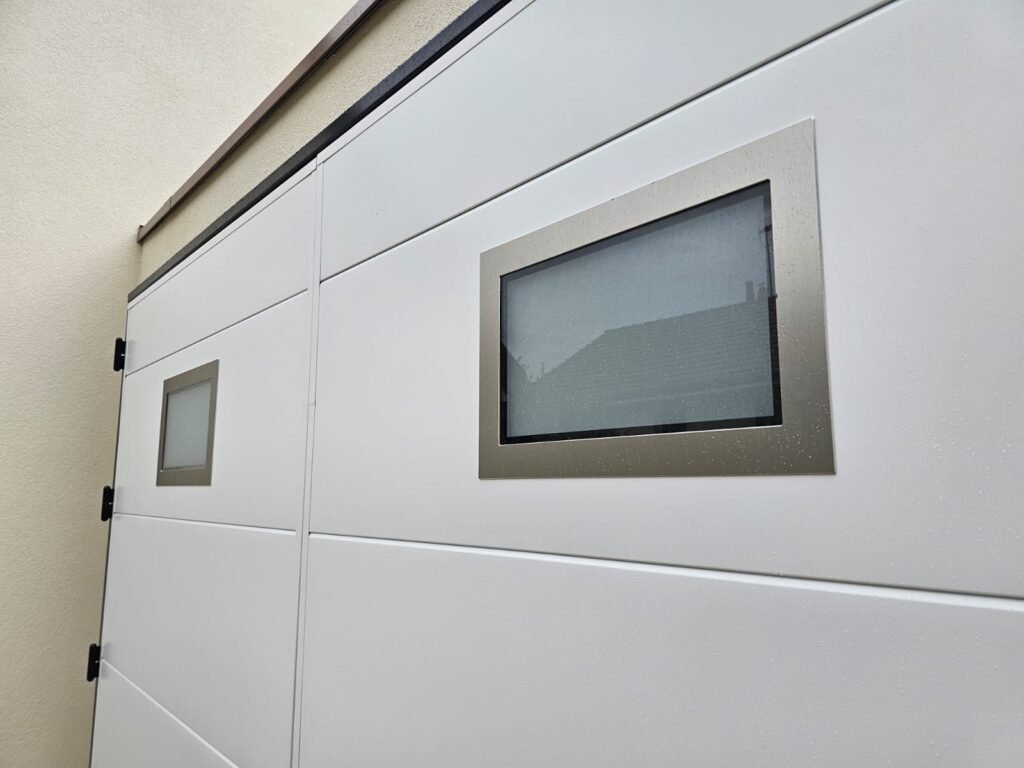 Deux hublots rectangulaires en verre dépoli avec cadre inox sur une porte de garage Moos blanche à Dijon