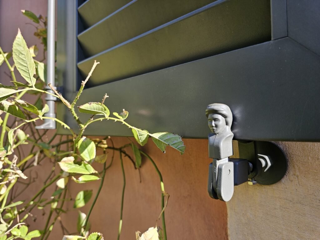 Arrêt bergère en forme de petit buste maintenant un volet battant aluminium Ehret gris RAL 7022